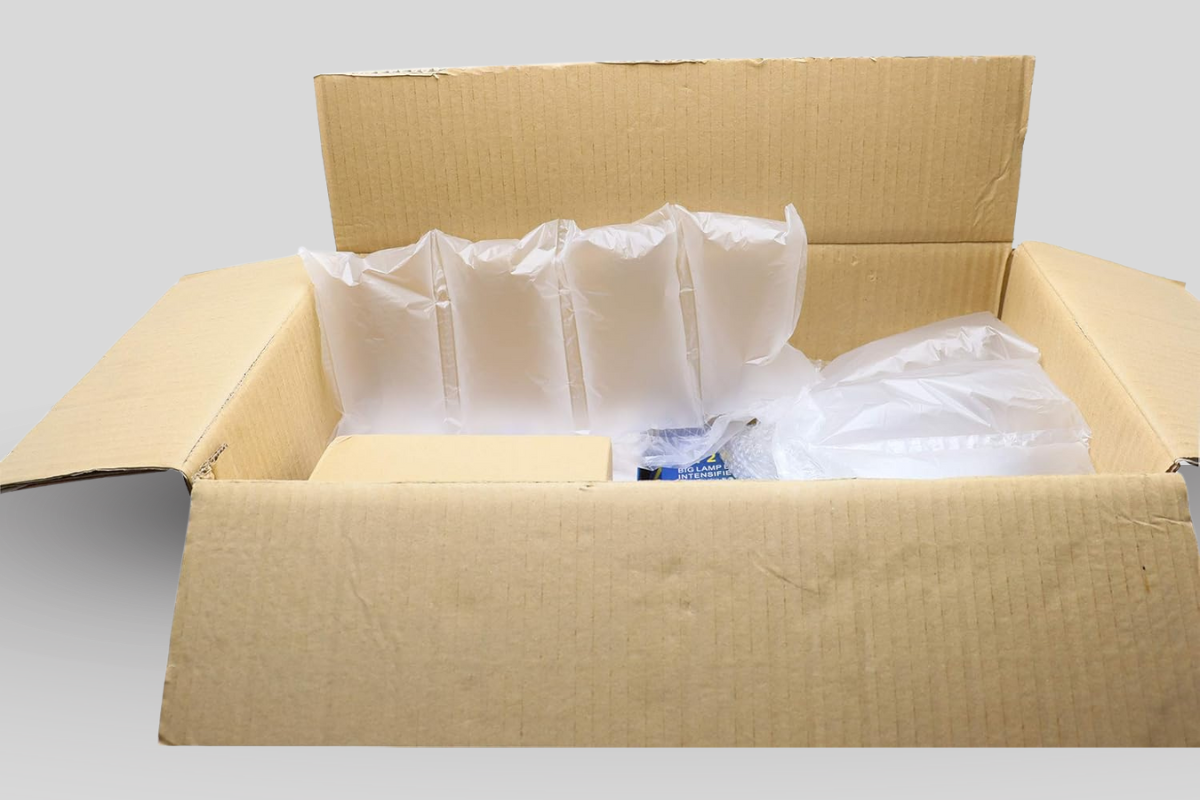 Cardboard box with air cushion packaging used for safe and space-efficient e-commerce shipping.