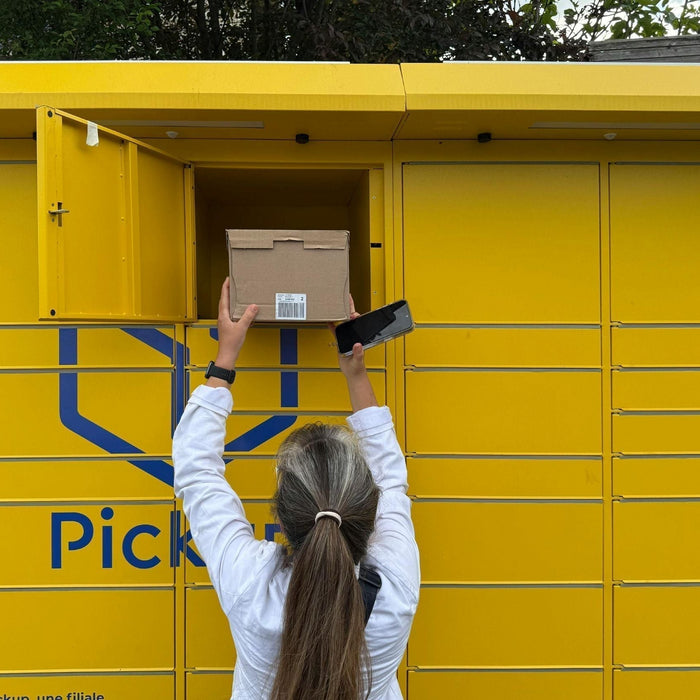 Customer inserting a parcel into a yellow parcel locker – illustrating parcel locker box sizes.